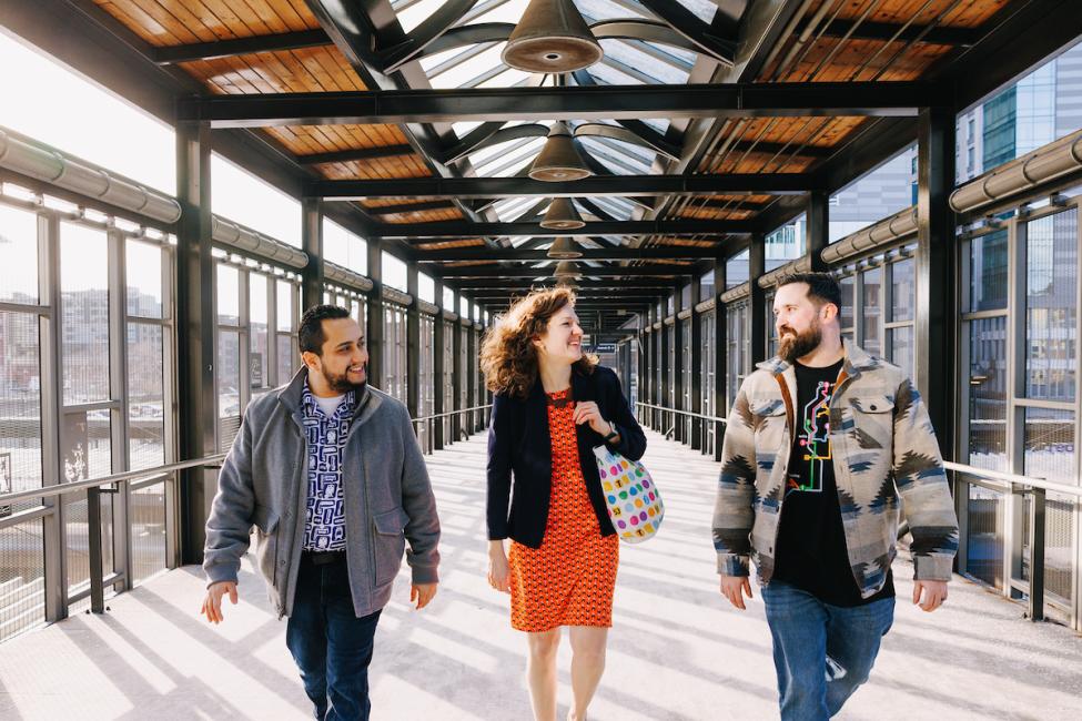 A group of people walk and smile wearing Sound Transit shop items