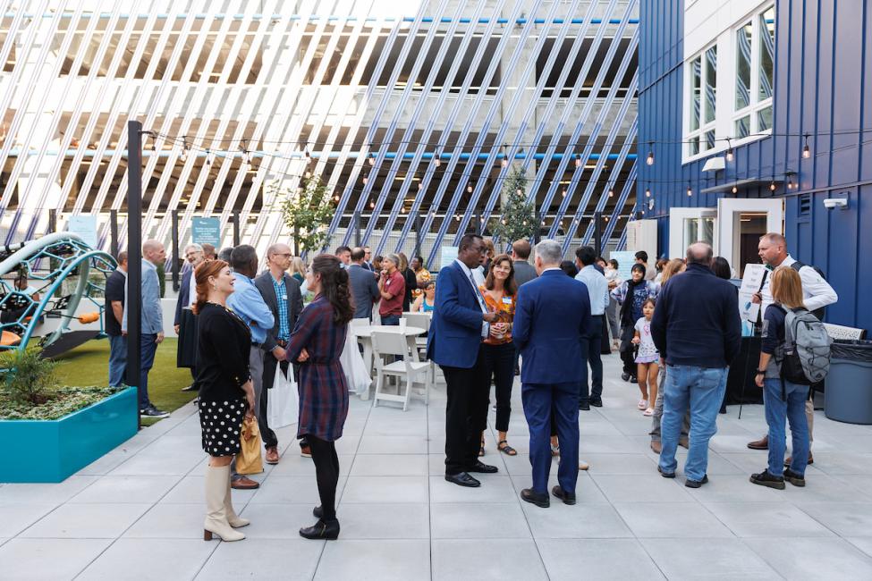 A gathering of people to celebrate the grand opening of a new transit-oriented development