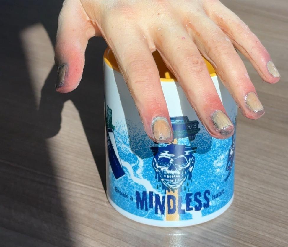 a prop zombie hand laid over Sound Transit's break a mindless habit mug