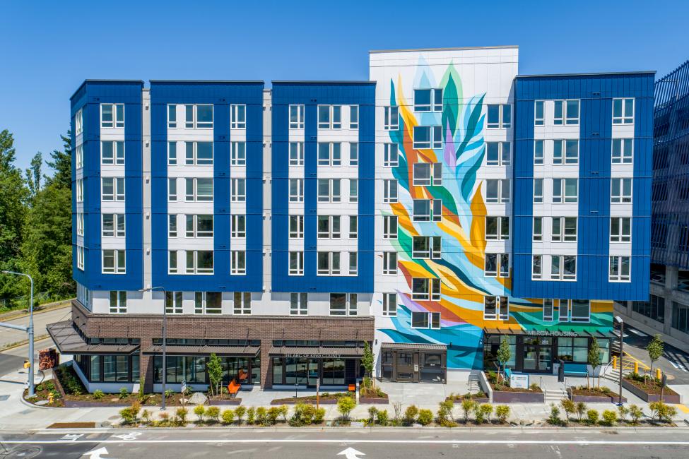 A colorful mural on the exterior of a mixed-use development