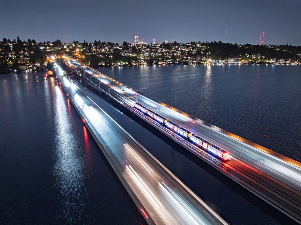The blur of a train crosses the I-90 bridge in the evening