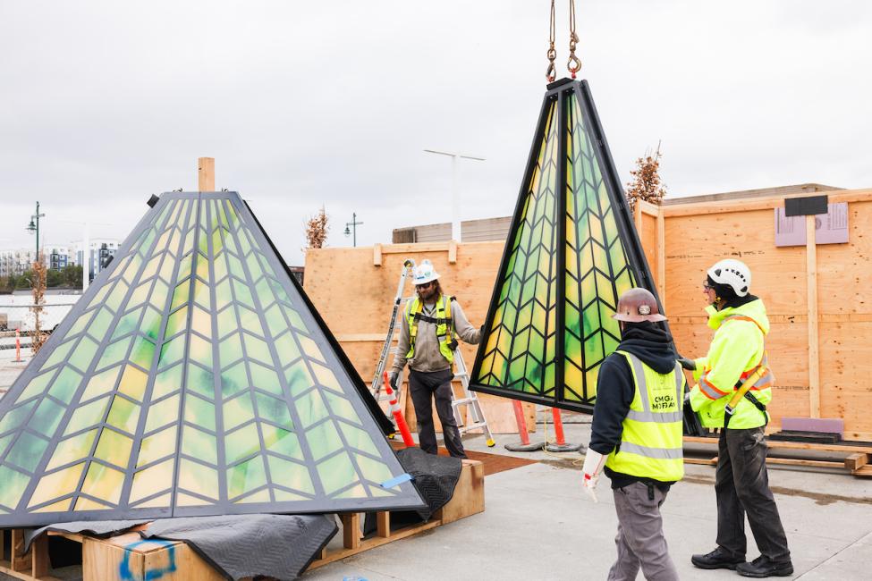 Workers lift art that looks like a lampshade into place in Federal Way