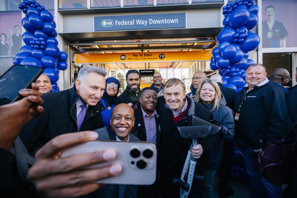 Sound Transit executives and board members smile for a cell phone photo at the opening of the 1 Line extension to Federal Way. 