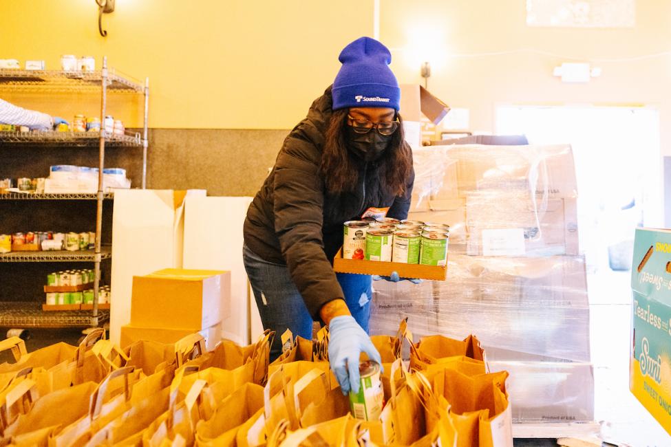 A Sound Transit employee places food in a brown bag.