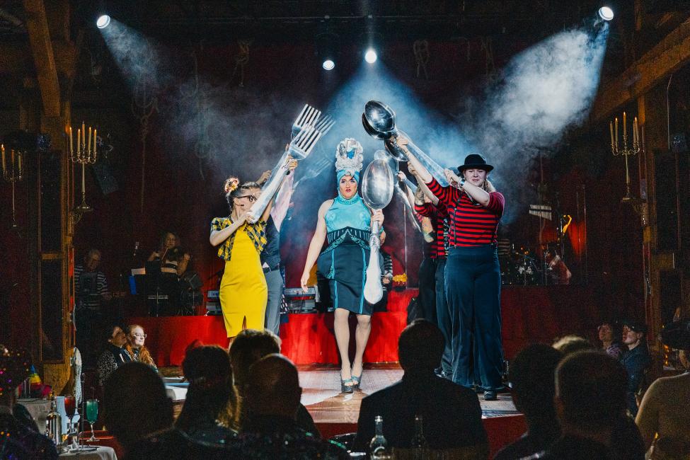 A crowd looks on as the spotlight shines on Teatro performers.