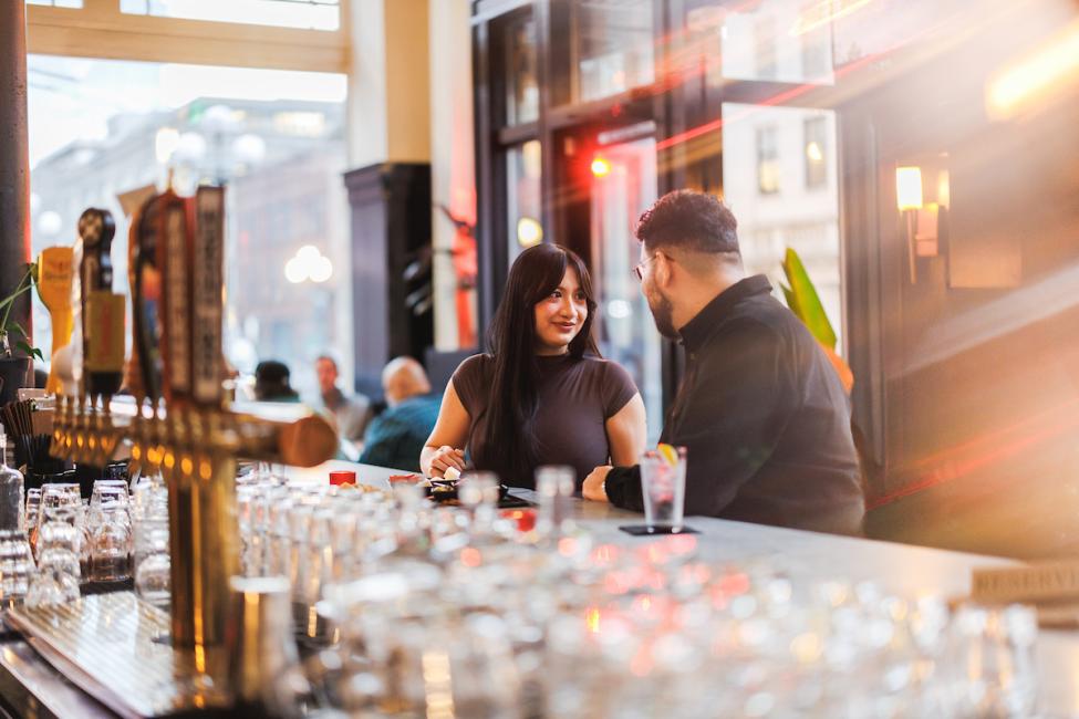 A couple sits at the bar at Good Bar.
