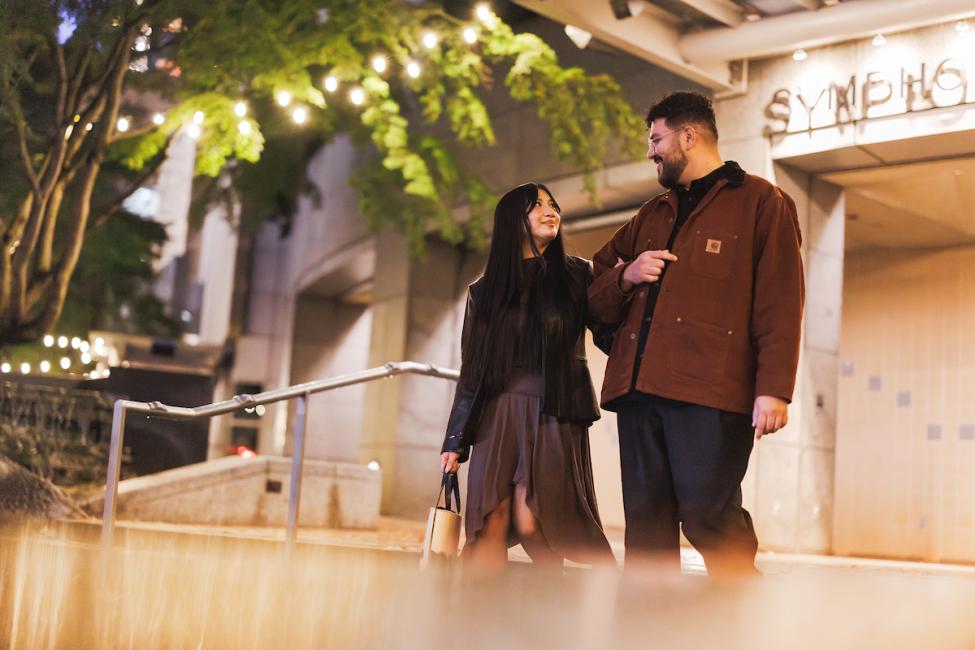 A couple walks arm in arm out of the exit of Symphony Station at nighttime