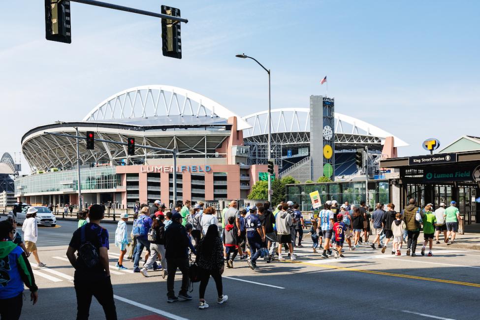 Soccer fans cross a street on their way to the stadium in downtown Seattle