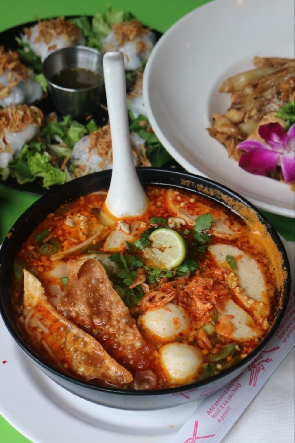 Three dishes on a table. The one in the middle is a flavorful soup