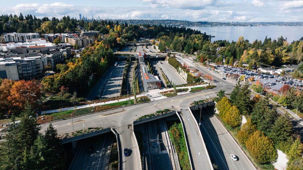 An aerial photo of I-90 on Mercer Island with the town center on the left, light rail station in the middle and parking garage on the right