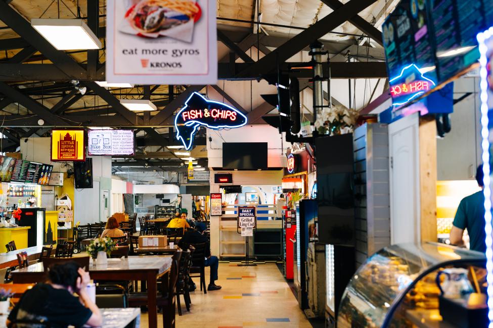 People sit at tables in the restaurant area of Freighthouse Square