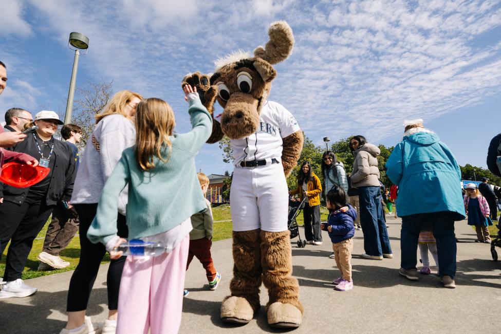 The Mariner Moose gives a kid a high-five at the Crosslake Connection opening celebration