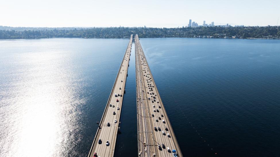 An aerial view of cars and train tracks on the I-90 floating bridges on Lake Washington