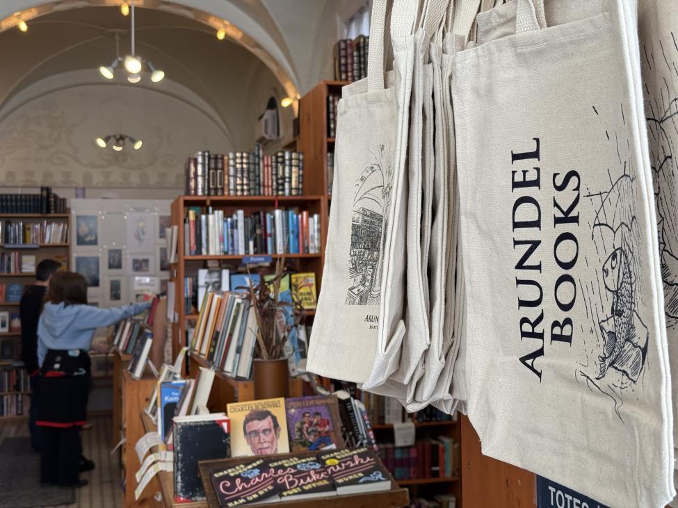 Tote bags on a wall at Arundel Books feature the name of the store