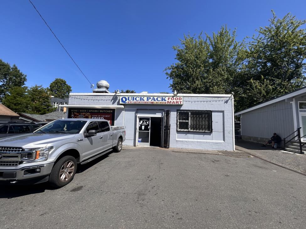 A portrait shot of the storefront for Quick Pack Food Mart