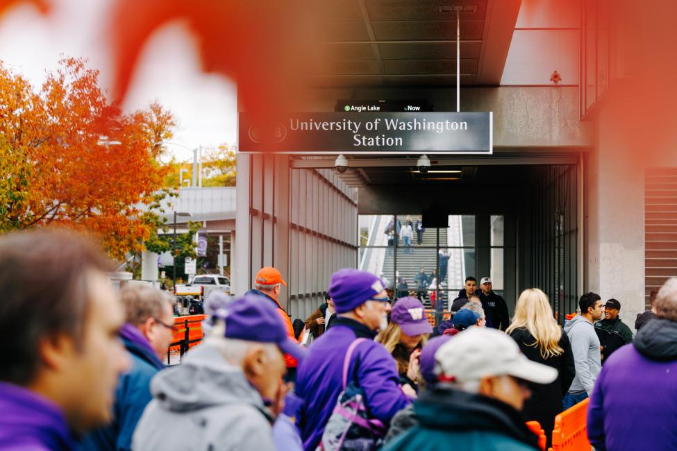 Fans walk from University of Washington Station into the football stadium