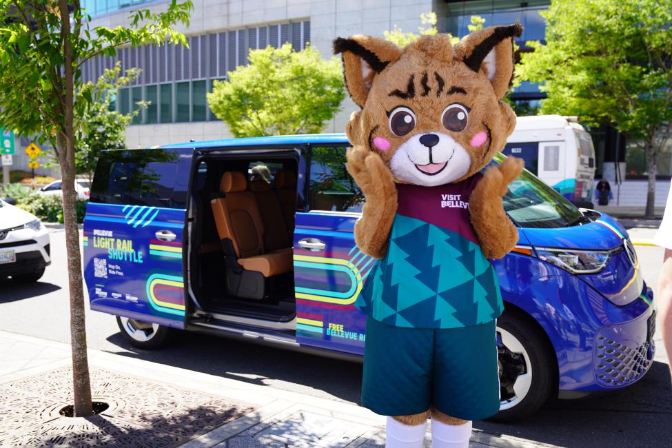 A bobcat mascot in front of a blue shuttle 