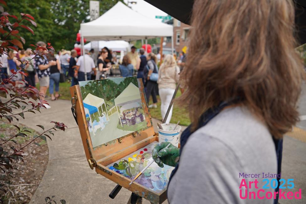 A painter and their easel in front of a crowd of people