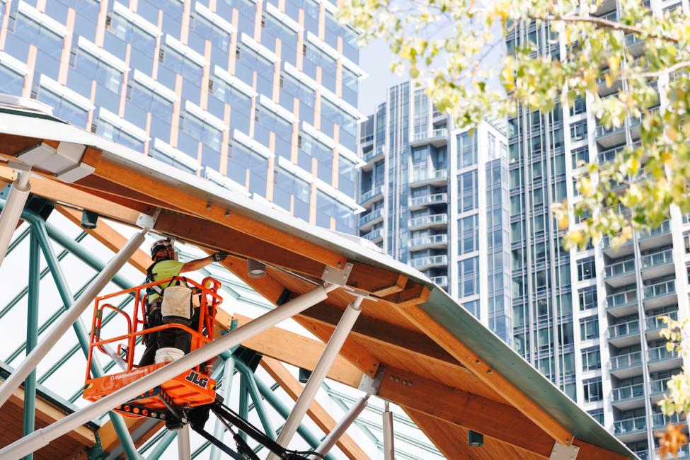 A worker in a lift uses a tool during Bellevue Transit Center construction 