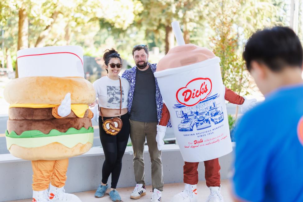 The Dick's Drive-In Burger and shake mascot pose for a photo with passengers