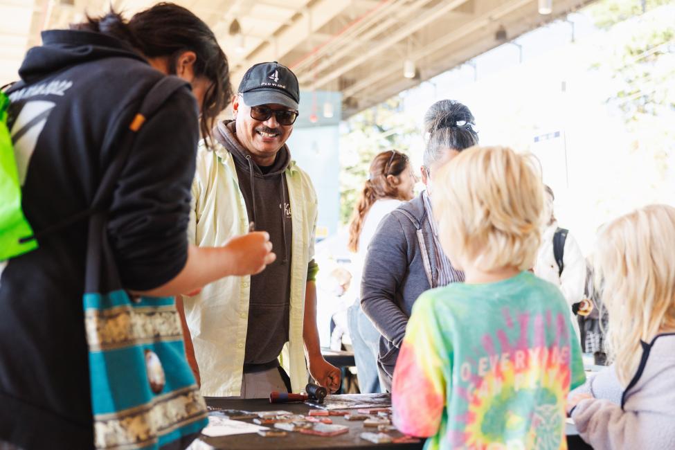 Artist Romson Bustillo helps people create their own art at the Pinehurst Station opening celebration