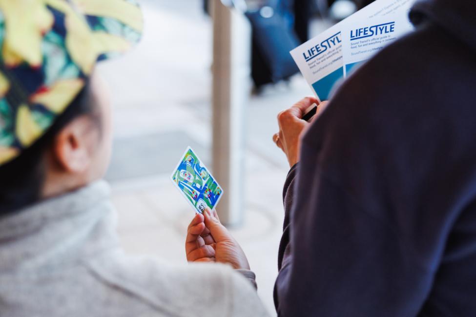 A passenger holds a commemorative ORCA card and commemorative maps