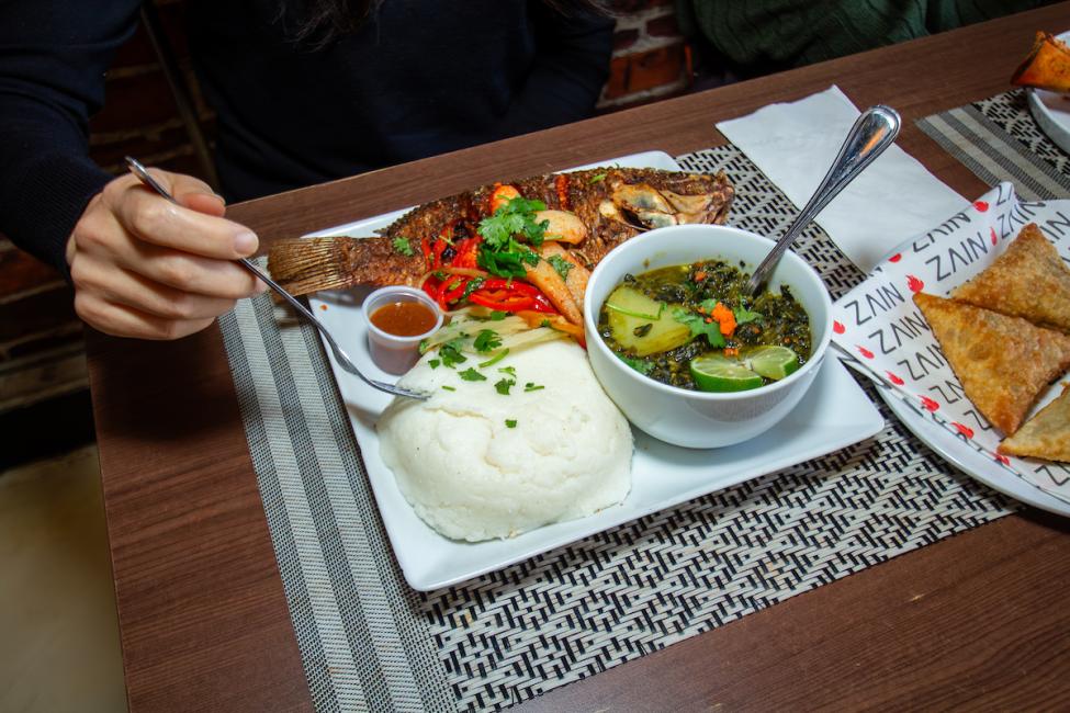 A platter of food from Zain, including fish, rice, and sauce