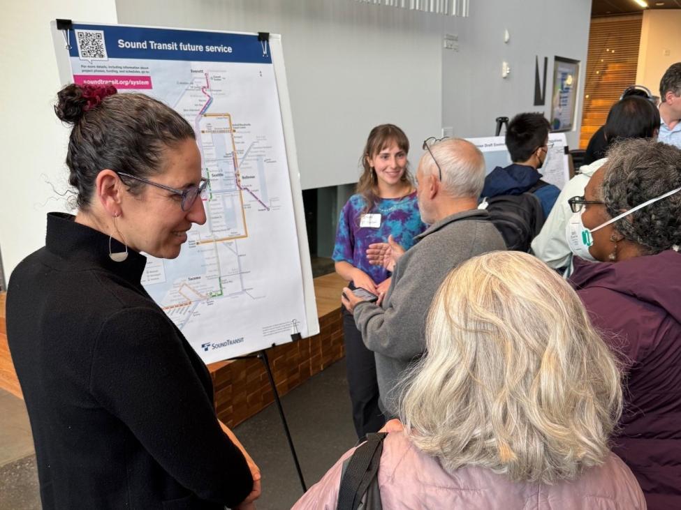 Community engagement staffers from Sound Transit talk to community members at a forum in Ballard