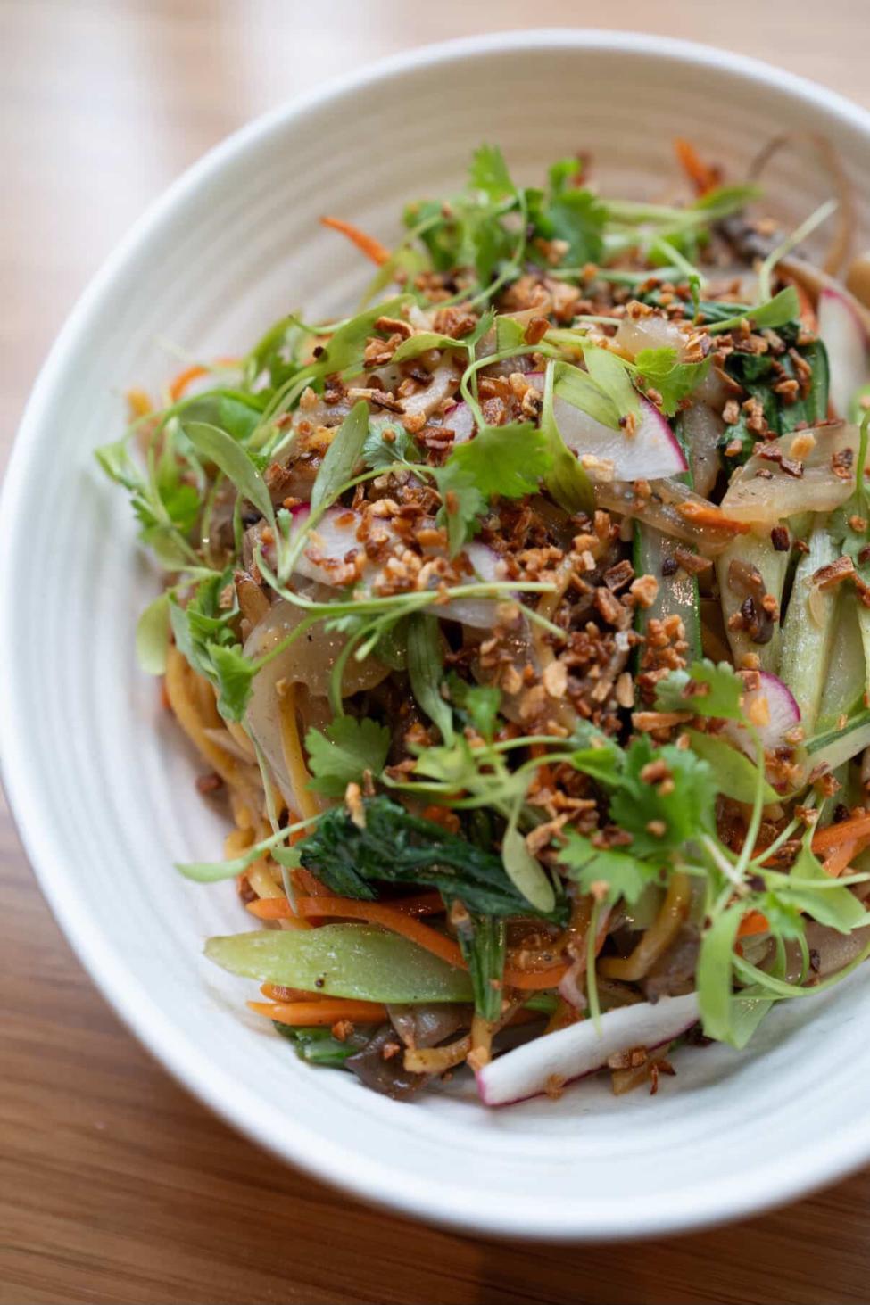 A dish of pancit - wok-tossed canton noodles with crisp snap peas, leeks, mushrooms, carrots and more