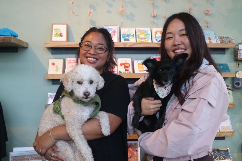 Two people hold dogs in the store Sairen in Seattle's Filipino Town