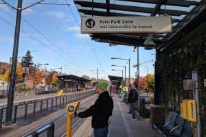 A rider taps his ORCA card at the reader at the Columbia City Link light rail platform