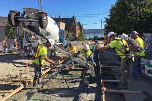 Contractors pour concrete for the track installation on North 1st Street near Stadium High School.