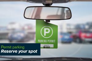 A parking permit hangs from a rear view window in a car.