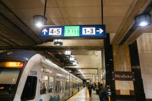 New overhead signage in Westlake Station displays a large green 'exit' icon and points riders to numbered exits (1 through 5).