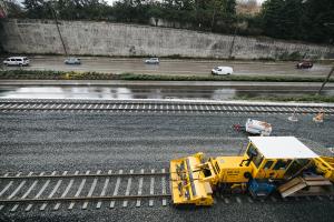 A large piece of construction equipment is pictured on the rails next to I-90 in Mercer Island.