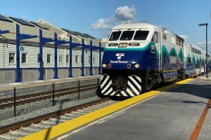 A Sounder train pulls into Tacoma Dome Station on a sunny day.