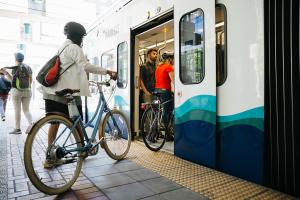 Tacoma Dome Link Extension Open house event header image, photo of bike rider boarding the train