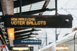 A graphic shows a digital sign on a Link platform and reads "Now arriving: Voter ballots."