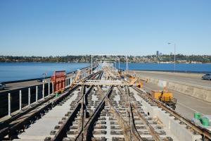 Train tracks are installed on the floating bridge between Seattle and the Eastside on a sunny day.