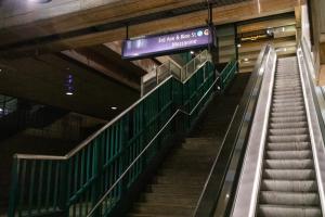 Looking up from the platform at a set of stairs and an escalator in the Downtown Seattle Transit Tunnel.