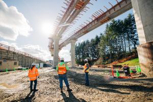 Workers dwarfed by the elevated tracks heading into Mountlake Terrace Station. 