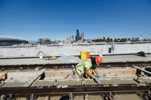 A worker smooths concrete on the new light rail tracks leading into the International District/Chinatown Station from the Eastside.