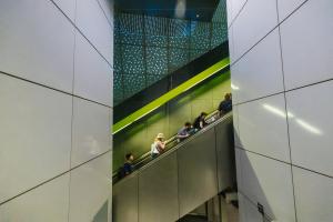 People ride an escalator at University of Washington Station.