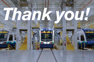 Photo of a link light rail train with the words "Thank you" above the train, Operations and Maintenance Facility South