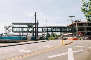 A pedestrian bridge is being constructed over a street in Puyallup on a sunny day.