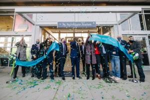 Sound Transit board members cut the teal ribbon to open Northgate Station as confetti flies.
