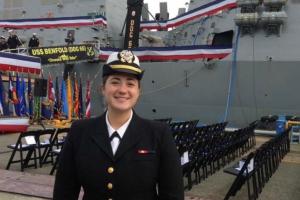 Presley Morrisey in her Navy uniform with a boat in the background.
