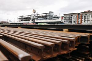 A stack of rail in the foreground, with the Federal Way Transit Center in the background.