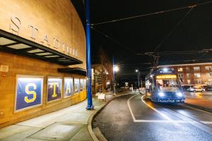 A T Line train drives next to Stadium High School.