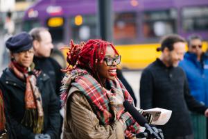 Simbi speaks into a microphone outside Union Station, with other Sound Transit employees in the background